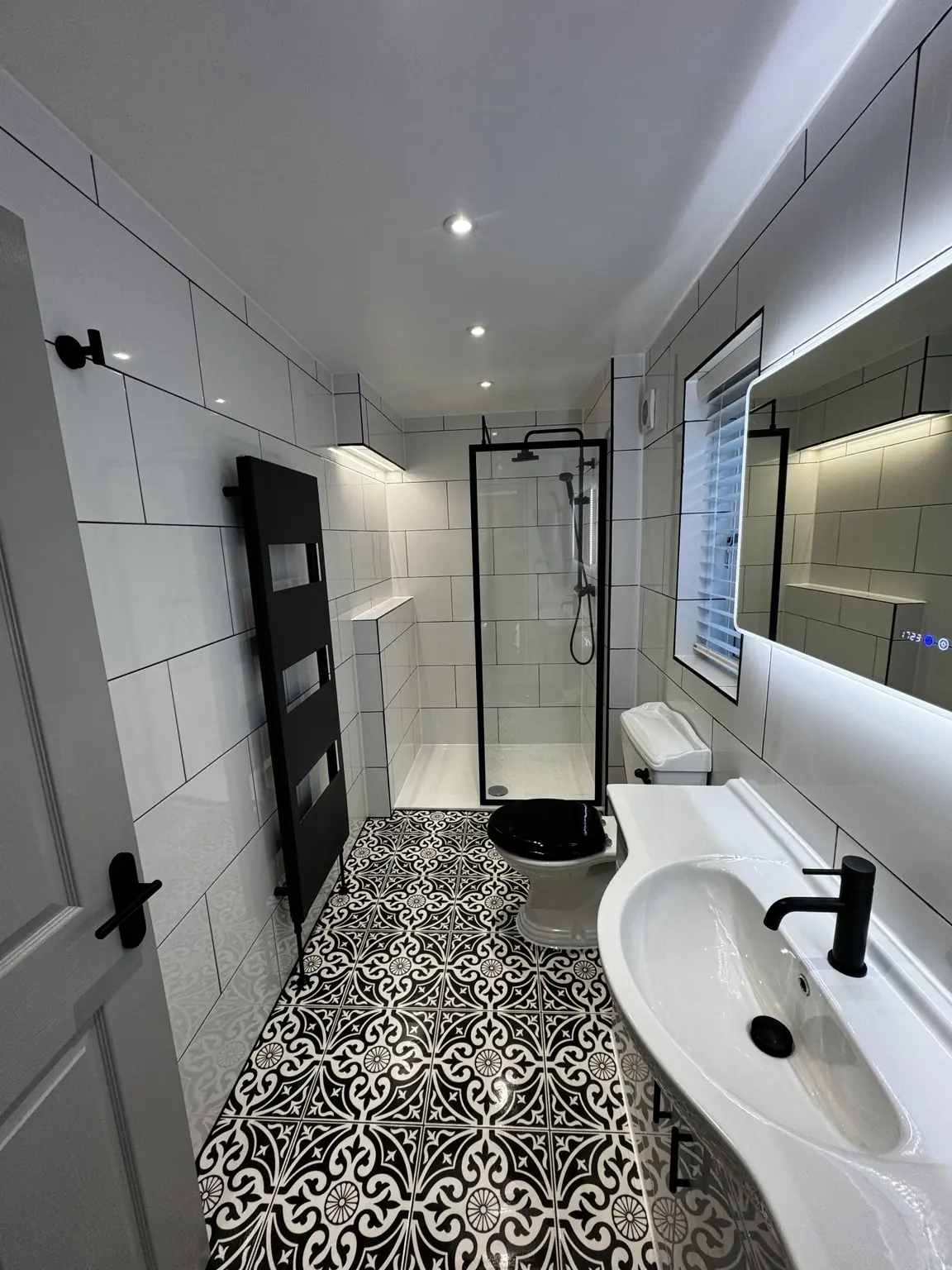 Luxury bathroom lighting installation in Kettering with LED downlights, concealed shower lighting and illuminated mirror