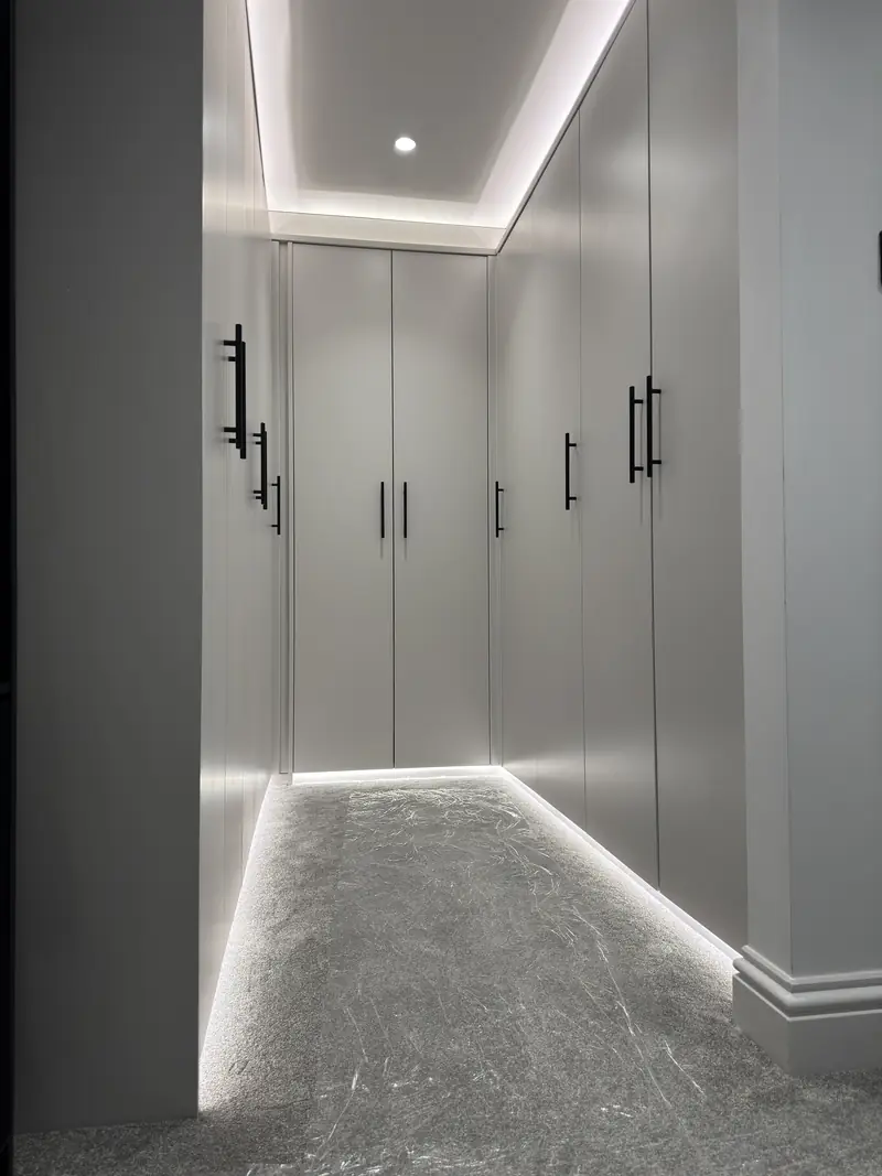 Luxury walk-in wardrobe lighting installation in Kettering with LED strip lighting and recessed spotlights